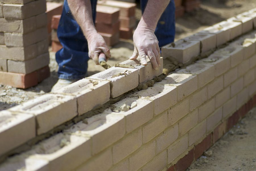 Mason laying a brick retaining wall